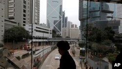 FILE - A woman walks on a bridge near the Central district of Hong Kong, Wednesday, Feb. 24, 2016. More than 10,000 people wrote to TVB to complain about the subtitles.