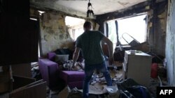 A local resident searches for intact items in his apartment in a residential building destroyed by a rocket attack the day before, in Kyiv, on July 9, 2024, amid Russia's invasion in Ukraine.