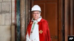 FILE - Archbishop of Paris Michel Aupetit arrives to attend a ceremony to celebrate Good Friday in a secured part of Notre-Dame de Paris cathedral, April 10, 2020, in Paris. 
