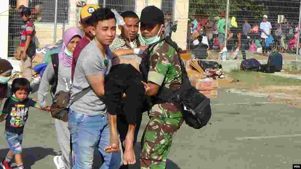 An injured person is taken toward an improvised medical care facility at Palu's airport on Sulawesi, Indonesia, Oct. 3, 2018. (Y. Litha/VOA)
