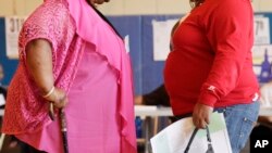 FILE - Two women converse in New York. New government figures released Friday, Oct. 13, 2017 showed small increases that were not considered statistically significant but were seen by some as a cause for concern. The adult obesity rate rose from to about 40 percent, from just shy of 38 percent.