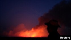 A man is seen on a burning tract of the Amazon jungle in Canarana, Mato Grosso state, Brazil, Aug. 26, 2019. 