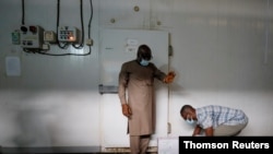 A worker prepares to store boxes of vaccines in a cold room as the country receives its first batch of coronavirus disease (COVID-19) vaccines under COVAX scheme, in Accra, Feb. 24, 2021.