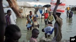 Des déplacés Sud-Soudanais marchent à travers les eaux d'inondations pour accéder à leur site d'hébergement près de la base de la Mission des Nations unies au Soudan du Sud (UNMISS) au village de Bentiu, Sudan du Sud, lundi 22 septembre 2014.