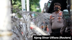 Seorang petugas polisi berjaga di luar gedung Pengadilan Negeri Jakarta Timur saat persidangan ulama Rizieq Shihab digelar di Jakarta, pada 27 Mei 2021. (Foto: Reuters/Ajeng Dinar Ulfiana)