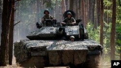 Tentara Ukraina dari brigade ke-57 mengendarai kendaraan tempur Swedia di dekat medan pertempuran di wilayah Kharkiv, Ukraina, pada 18 Juni 2024. (Foto: AP/Andrii Marienko)