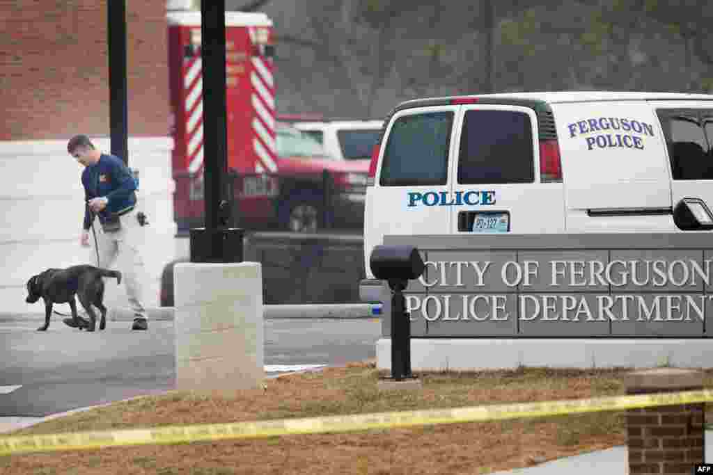 A K-9 unit patrols outside the Ferguson, Mo., police station after two officers were shot and wounded during Wednesday night&#39;s protest.