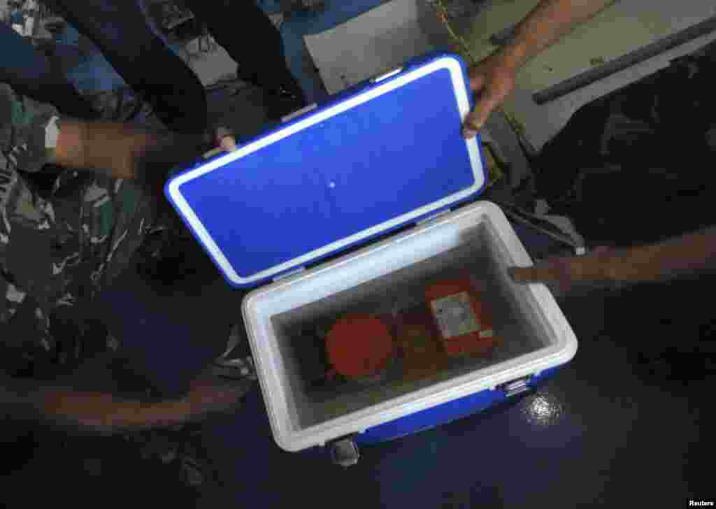 Indonesian soldiers show the cockpit voice recorder of AirAsia 8501 on the deck of KRI Banda Aceh, in the Java Sea, Jan. 13, 2015.