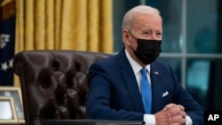 US President Joe Biden delivers remarks on immigration, in the Oval Office of the White House, Feb. 2, 2021, in Washington.