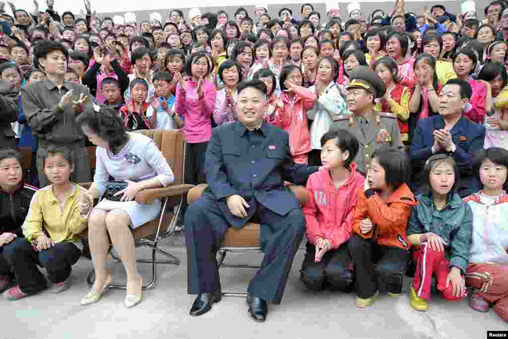 Pemimpin Korea Utara Kim Jong-un (tengah) dan isterinya Ri Sol-ju saat berkunjung ke kamp anak-anak &#39;Pyongyang Myohyangsan&#39; yang terletak di kaki Gunung Myohyang di Provinsi Phyongan Utara (foto courtesy: KCNA).