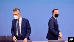 German Health Minister Jens Spahn, right, with Lothar Wieler, head of Germany's Robert Koch Institute for disease control, arrive for a press conference on the situation of the coronavirus (COVID-19) pandemic in Germany, in Berlin, Apr. 29, 2021.