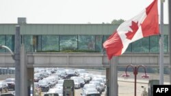 Antrean menyeberangi Jembatan Pelangi (Rainbow Bridge) di Air Terjun Niagara, Ontario, Kanada, 9 Agustus 2021. (Geoff Robins / AFP)