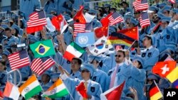 FILE - Columbia University students celebrate at the graduation ceremonies in 2019. A recent lawsuit claims Columbia and 15 others have worked together to limit financial aid to students. (AP Photo/Mark Lennihan)