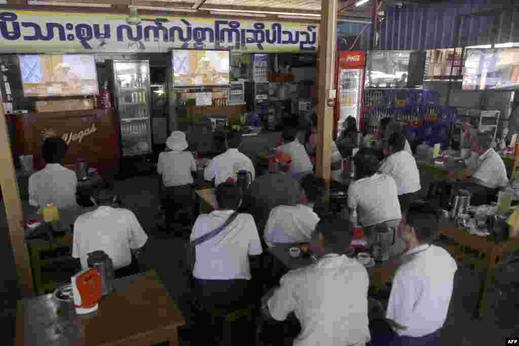 Customers at a coffee shop in Yangon watch a live television broadcast of new Myanmar President Htin Kyaw delivering his first address at the parliament in Naypyidaw during his swearing in ceremony.