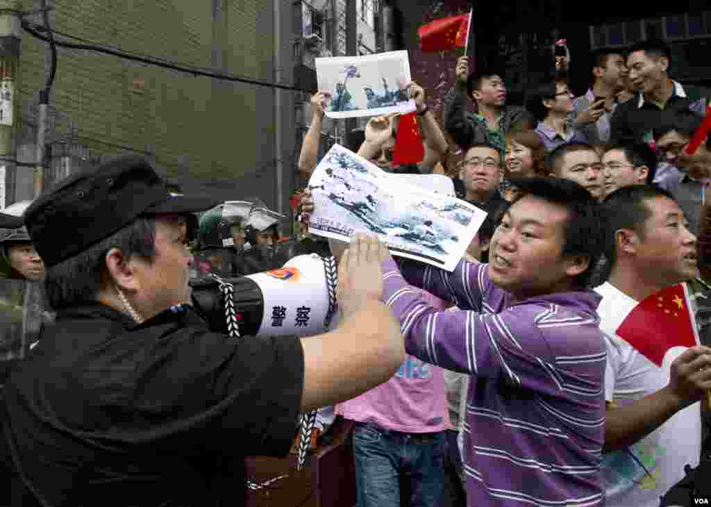 Protesters hold images they claim show Japanese imperial army soldiers who killed Chinese during World War II at an anti-Japan protest in Chengdu, Sichuan, China, Sepember 18, 2012.