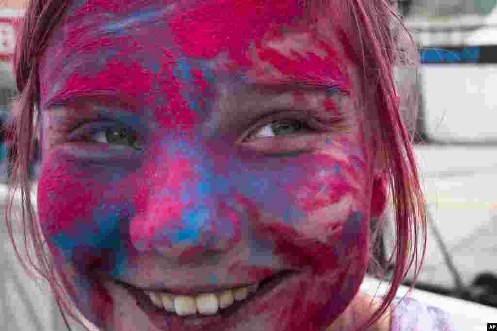 A girl is covered in colored paint during the Festival of Colors in Moscow, Russia.