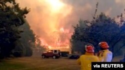 FILE PHOTO: Firefighters work at the scene of a bushfires in Bilpin, New South Wales, Australia in this still image from a social media video December 15, 2019. Andrew Mitchell/Cottage Point Rural Fire Brigade via REUTERS ATTENTION EDITORS - THIS…