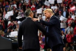 President Donald Trump, left, talks to Kentucky Gov. Matt Bevin, right, during a campaign rally in Lexington, Ky., Nov. 4, 2019.