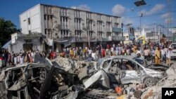 Watu wakiangalia uharibifu ulioachwa na magari mawili yaliyokuwa yametegwa mabomu kwenye makutano yenye shughuli nyingi huko Mogadishu, Somalia, Jumapili, Oktoba 30, 2022.(AP)
