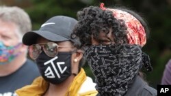 Protesters wear masks to help prevent the spread of the coronavirus, June 5, 2020, in Tacoma, Wash.