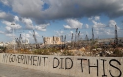 FILE - Words are written by Lebanese citizens in front of the scene of Tuesday's explosion that hit the seaport of Beirut, Lebanon, Aug. 9, 2020.