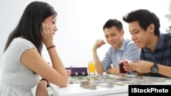 A group of friends play a board game at a cafe.