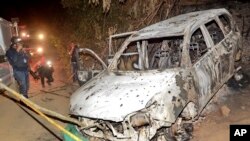 Photographers take photos of the burnt vehicle in which the body of mayoral candidate Karina Garcia who was found in Suarez, Colombia, Sept. 2, 2019.