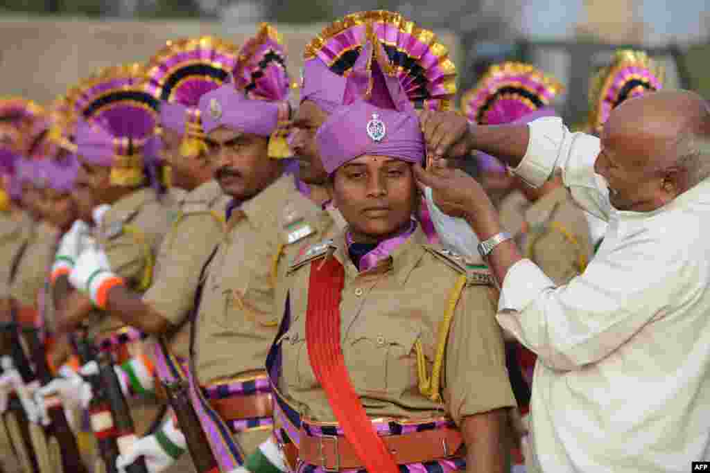 Seorang anggota polisi negara bagian Andhra Pradesh menungu penutup kepalanya selesai dirapikan saat ia dan anggota lainnya mempersiapkan gladi resik untuk parade hari Republik India di Secunderabad, kota kembar&nbsp; Hyderabad. India akan merayakan hari Republik India yang ke-65 pada 26 Januari.
