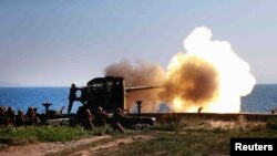 Tentara menembakkan artileri dalam sebuah kunjungan pemimpin Korea Utara Kim Jong Un di Ung Islet, Korea Utara.