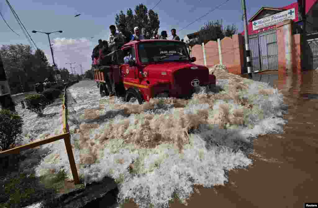 A truck evacuating Kashmiri flood victims to higher ground travels through a flooded street in Srinagar, India.