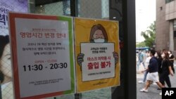 
Pemberitahuan perubahan jam kerja dan kewaspadaan terhadap virus corona, kanan, terlihat di salah satu pintu gerbang toko kecantikan di Seoul, Korea Selatan, Jumat, 28 Agustus 2020. (Foto: AP)
