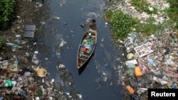Seorang pria dalam sebuah sampan mengumpulkan sampah plastik di sungai yang kotor di Dhaka, Bangladesh, 17 April 2019. (Foto:REUTERS/Mohammad Ponir Hossain)