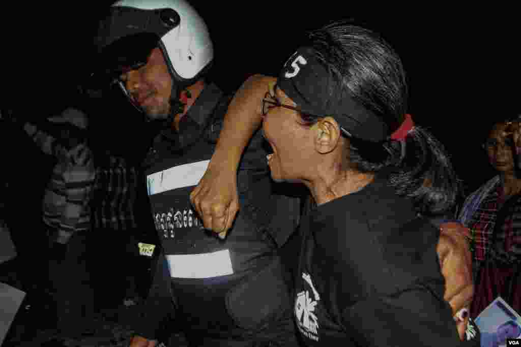 ប៉ូលិស​ម្នាក់​អូស​ស្រ្តីជា​បាតុករ​ម្នាក់​នៅ​កំឡុង​ពេល​​តវ៉ាជា​ការ​​អុជទៀន​ ​ក្នុង​ពេល​ធ្វើ​​យុទ្ធនាការ​&laquo;​ថ្ងៃ​ច័ន្ទ​ពណ៌ខ្មៅ&raquo;​​នៅ​សហគមន៏​បឹងកក់​នៃ​រាជធានី​ភ្នំពេញ ​កាលពី​ថ្ងៃ​ច័ន្ទ ​ទី​២៣ ខែ​ឧសភា​នេះ​ ដើម្បីទាមទារ​ឲ្យមាន​ការដោះលែងមន្រ្តី​សិទ្ធិមនុស្ស​៤រូប​ និង​មន្រ្តីគ.ជ.ប​​មួយរូប​ ដែល​ជាប់​ពន្ធនាគារ​កាលពី​ដើម​ខែ​ឧសភា​នេះ។​ (ឡេង ឡែន/VOA)