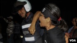 រូប​ឯកសារ៖ ប៉ូលិស​ម្នាក់​អូស​ស្រ្តីជា​បាតុករ​ម្នាក់​នៅ​កំឡុង​ពេល​​តវ៉ាជា​ការ​​អុជទៀន​ ​ក្នុង​ពេល​ធ្វើ​​យុទ្ធនាការ​«​ថ្ងៃ​ច័ន្ទ​ពណ៌ខ្មៅ»​​នៅ​សហគមន៏​បឹងកក់​នៃ​រាជធានី​ភ្នំពេញ ​កាលពី​ថ្ងៃ​ច័ន្ទ ​ទី​២៣ ខែ​ឧសភា​នេះ​ ដើម្បីទាមទារ​ឲ្យមាន​ការដោះលែងមន្រ្តី​សិទ្ធិមនុស្ស​៤រូប​ និង​មន្រ្តីគ.ជ.ប​​មួយរូប​ ដែល​ជាប់​ពន្ធនាគារ​កាលពី​ដើម​ខែ​ឧសភា​នេះ។​ (ឡេង ឡែន/VOA)