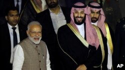 Putra Mahkota Arab Saudi Mohammed bin Salman (dua dari kanan) dan PM India Narendra Modi (kiri) di bandara New Delhi, India, 19 Februari 2019.