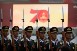 FILE - Members of a Chinese military honor guard stand at attention during a rehearsal before a parade to commemorate the 70th anniversary of the founding of Communist China, in Beijing, Oct. 1, 2019.