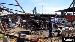 Seorang polisi berdiri di sebuah lokasi ledakan bom di Shuala, Baghdad (19/3). Cabang Al-Qaida di Irak menyatakan bertanggung jawab atas serangan di Baghdad dan sekitarnya dan memperingatkan akan melancarkan serangan susulan. 