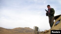 Afghan National Army soldiers keep watch outside of a military compound after a car bomb blast on the outskirts of Ghazni city, Afghanistan, Nov. 29, 2020. 