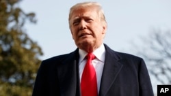 President Donald Trump pauses as he talks to media before boarding Marine One on the South Lawn of the White House in Washington, Dec. 8, 2018.