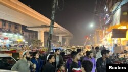 People come out of a restaurant after a tremor was felt in Lahore