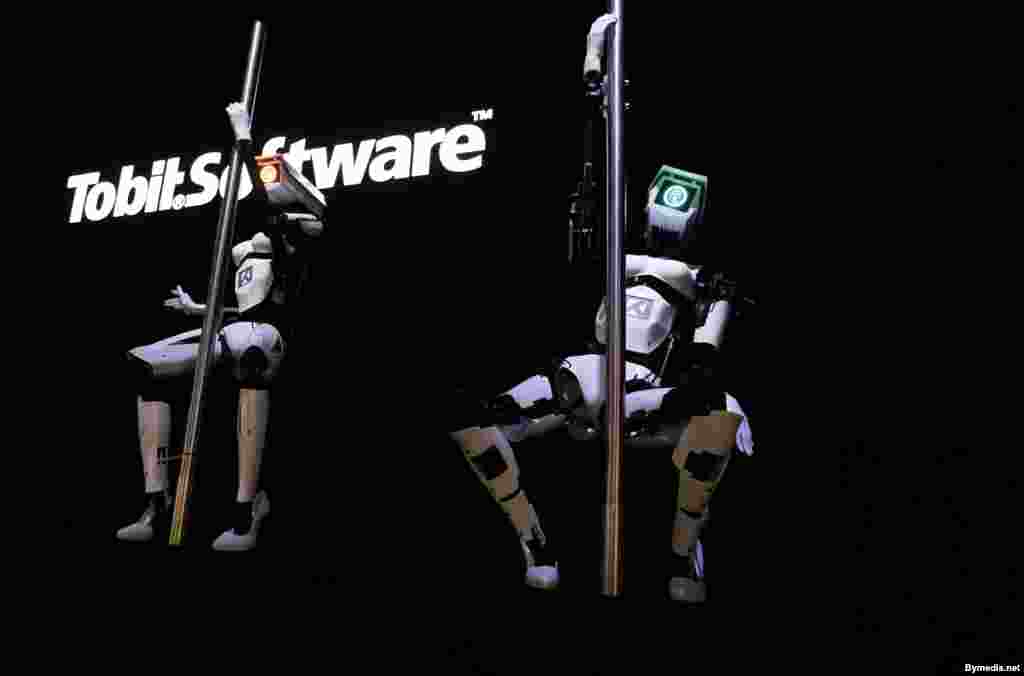 Dua robot perempuan melakukan dansa pada tiang dalam pameran teknologi di kota Hannover, Jerman.&nbsp;