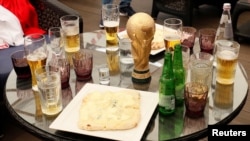 میزی با نوشیدنی‌های الکلی و ماکت کوچک کاپ قهرمانی هنگام برگزاری فینال جام جهانی ۲۰۱۸ میان فرانسه و کرواسی (آرشیو) 