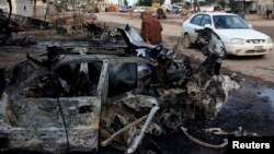 A man walks past the site of car bomb attack in Buhriz, northeast of Baghdad, Dec. 9 2013. 