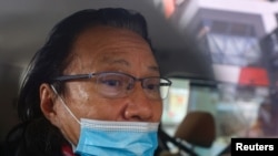 Daniel Wong Kwok-tung, seorang pengacara yang mencoba membantu 12 orang yang ditahan di daratan China, terlihat di dalam kendaraan polisi di Hong Kong, China, 14 Januari 2021. (Foto: REUTERS/Tyrone Siu)