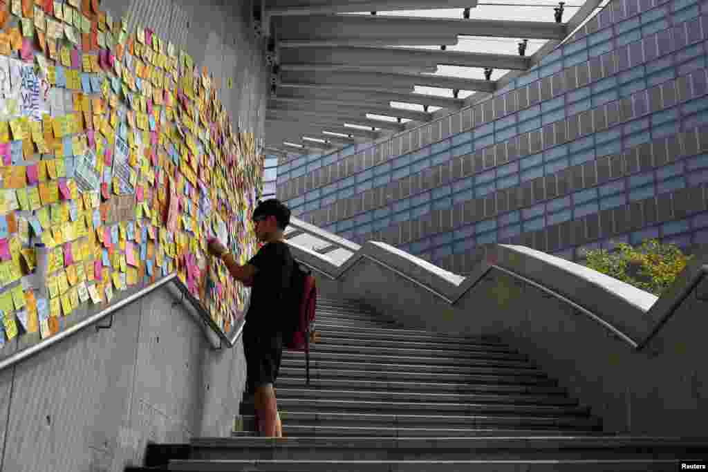 A student writes a message of support for the pro-democracy demonstrations and sticks it onto a wall in Hong Kong, Oct. 2, 2014.