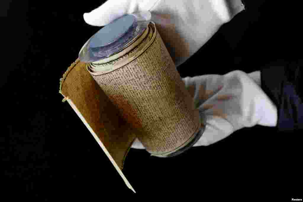 An employee displays the Marquis de Sade&#39;s original rolled manuscript called Le Rouleau de la Bastille of &quot;Les 120 jours de Sodome ou l&#39;ecole du libertinage&quot; (The 120 Days of Sodom, or the School of Libertinage, 1785) before its auction at the Hotel Drouot auction house in Paris, France.