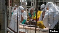 Petugas medis Inggris merawat pasien baru yang terjangkit Ebola di sebuah pusat penanggulangan Ebola "Kerry Town" di luar kota Freetown, Sierra Leone (22/12).