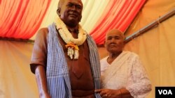 Kem Ley’s mother, Phok Se, 77, stands next to a statue of her son, slained political analyst, Sunday, October 15, 2016 in Takeo province, Cambodia. (Leng Len/VOA Khmer)