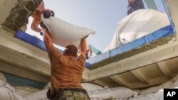 In this photo released by the U.S. Navy, sailors inventory urea and ammonium perchlorate found on a dhow intercepted in the Gulf of Oman on Nov. 9, 2022.