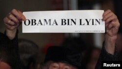 Pendukung Mitt Romney membawa tulisan "Obama Bin Lyin'" sebelum kampanye capres partai Republik Mitt Romney (foto: dok). Tim kampanye Romney dan Obama saling serang dengan memasang iklan negatif atas lawan politiknya di TV. 